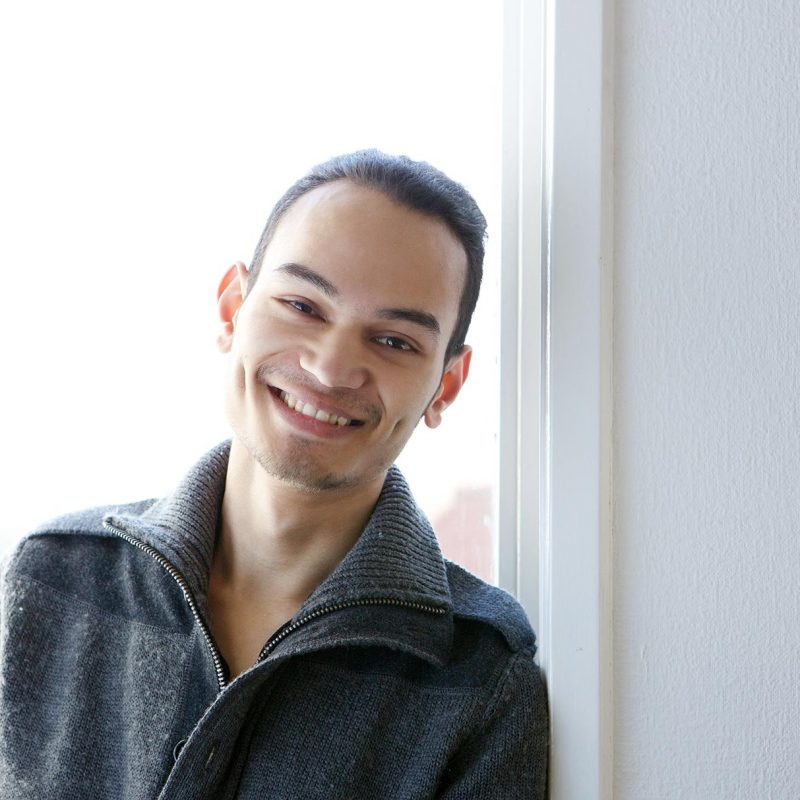 young-asian-man-smiling-at-home-PBGE75L
